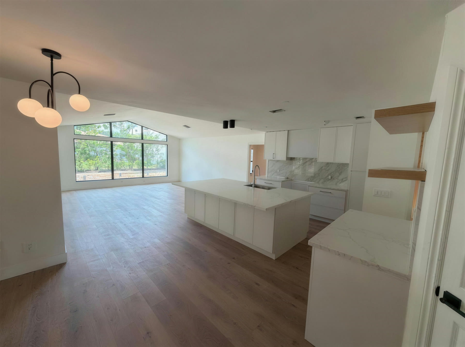 Renovated open-concept kitchen and great room with marble waterfall island
