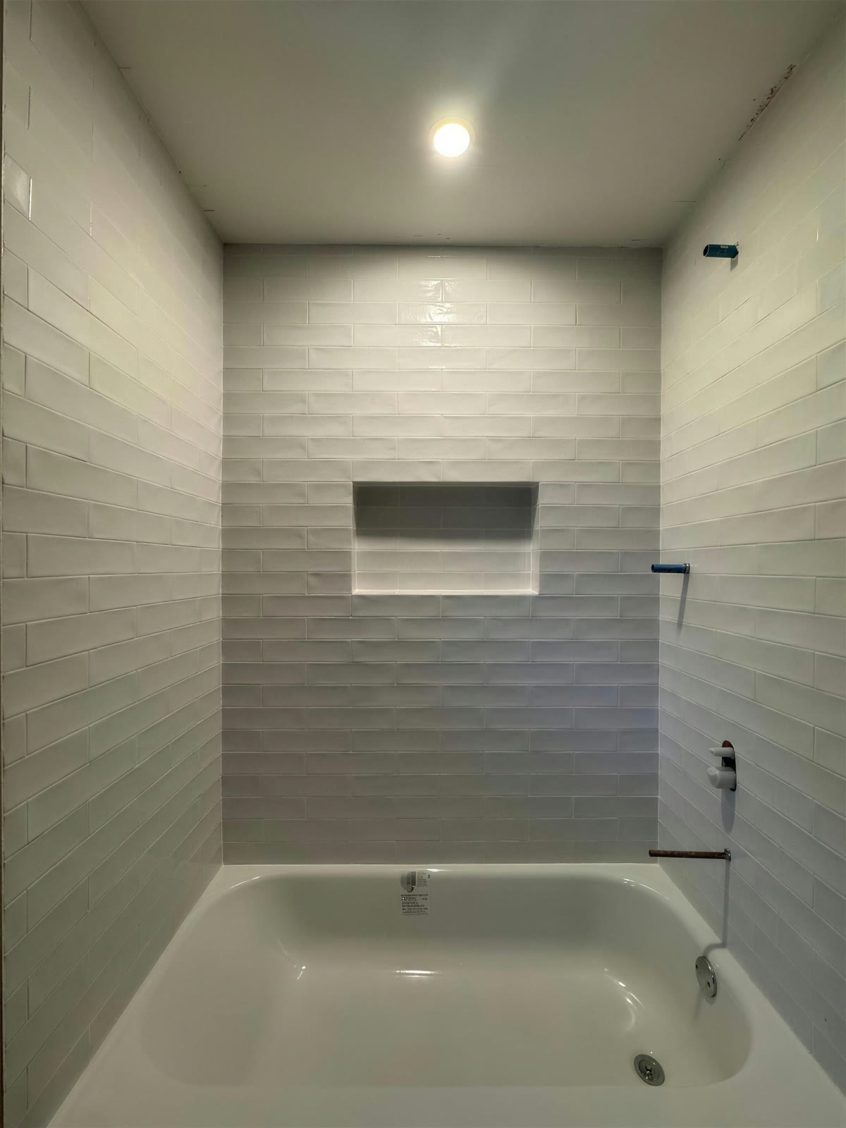 Bathroom with white subway tile and a soaking tub